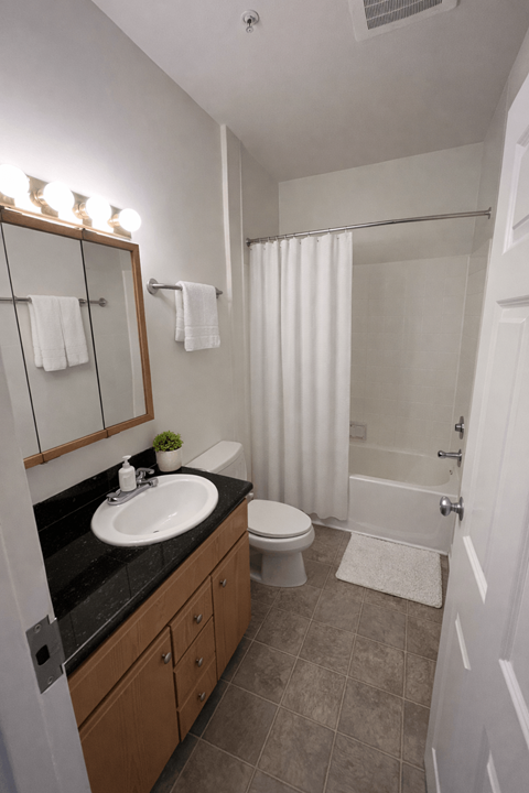 A bathroom with a sink, toilet, and shower.